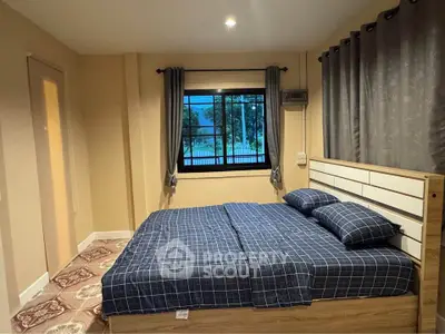Cozy bedroom with modern decor and large window offering natural light