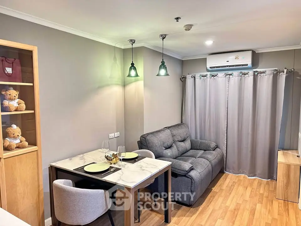 Cozy living room with modern decor, featuring a plush sofa and elegant dining area.