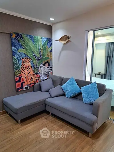 Stylish living room with modern gray sectional sofa and vibrant wall art, perfect for relaxation.