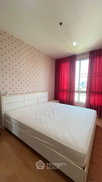 Spacious bedroom with large window and stylish wallpaper