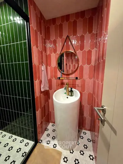 Stylish bathroom with modern pink tiles and sleek pedestal sink