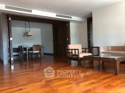 Spacious living room with wooden flooring and elegant dining area