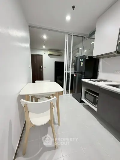 Modern kitchen with sleek appliances and dining area in a stylish apartment.