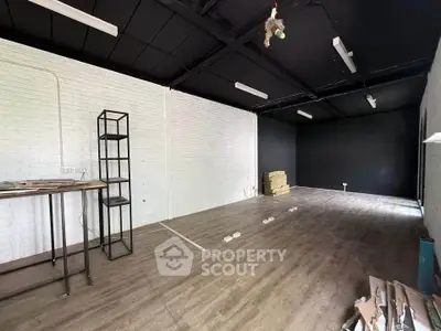 Spacious industrial-style room with high ceilings and modern lighting, perfect for creative workspace or studio.