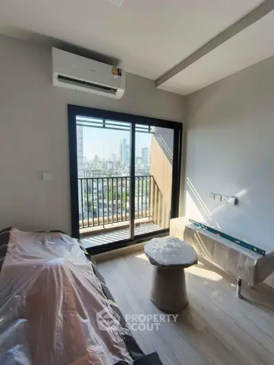 Modern apartment with balcony and city view, featuring air conditioning and sleek interior design.