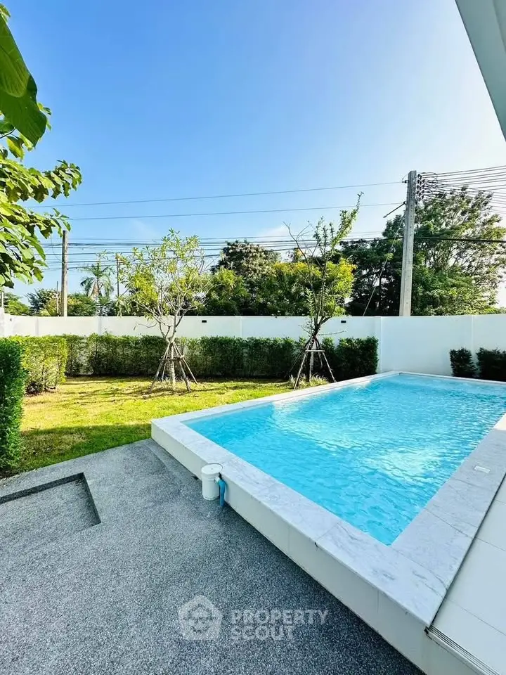 Luxurious outdoor pool with lush garden in serene residential setting