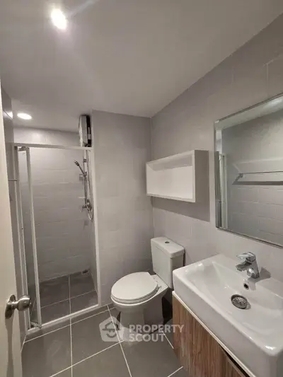 Modern bathroom with sleek fixtures and walk-in shower in contemporary apartment.