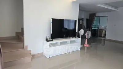 Spacious modern living room with sleek TV setup and glossy tiled flooring