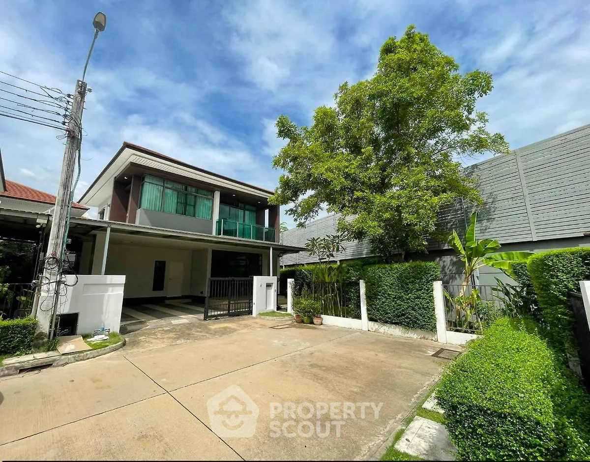 Modern two-story house with spacious driveway and lush greenery, perfect for family living.