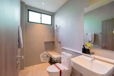 Modern bathroom with sleek fixtures and natural light from a large window.