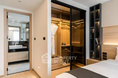 Luxurious bedroom with walk-in closet and modern bathroom in elegant apartment.