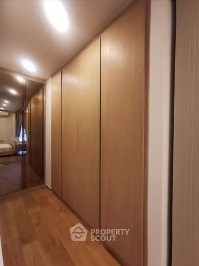 Spacious bedroom with elegant wooden wardrobes and mirrored sliding doors