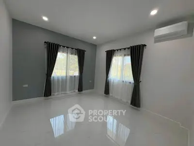 Spacious modern living room with large windows and air conditioning