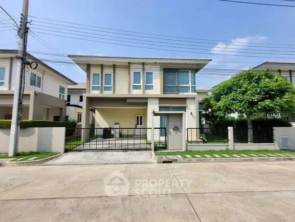 Modern two-story house with driveway and lush greenery in a serene neighborhood.