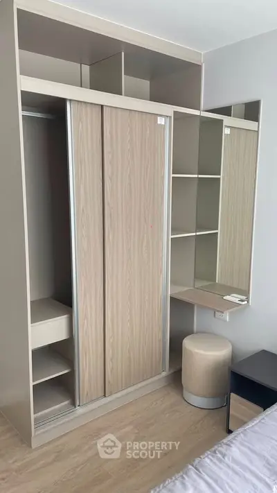 Modern bedroom with built-in wardrobe and vanity, featuring sleek design and ample storage space.
