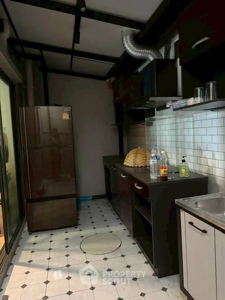 Modern kitchen with sleek black cabinets and stainless steel appliances