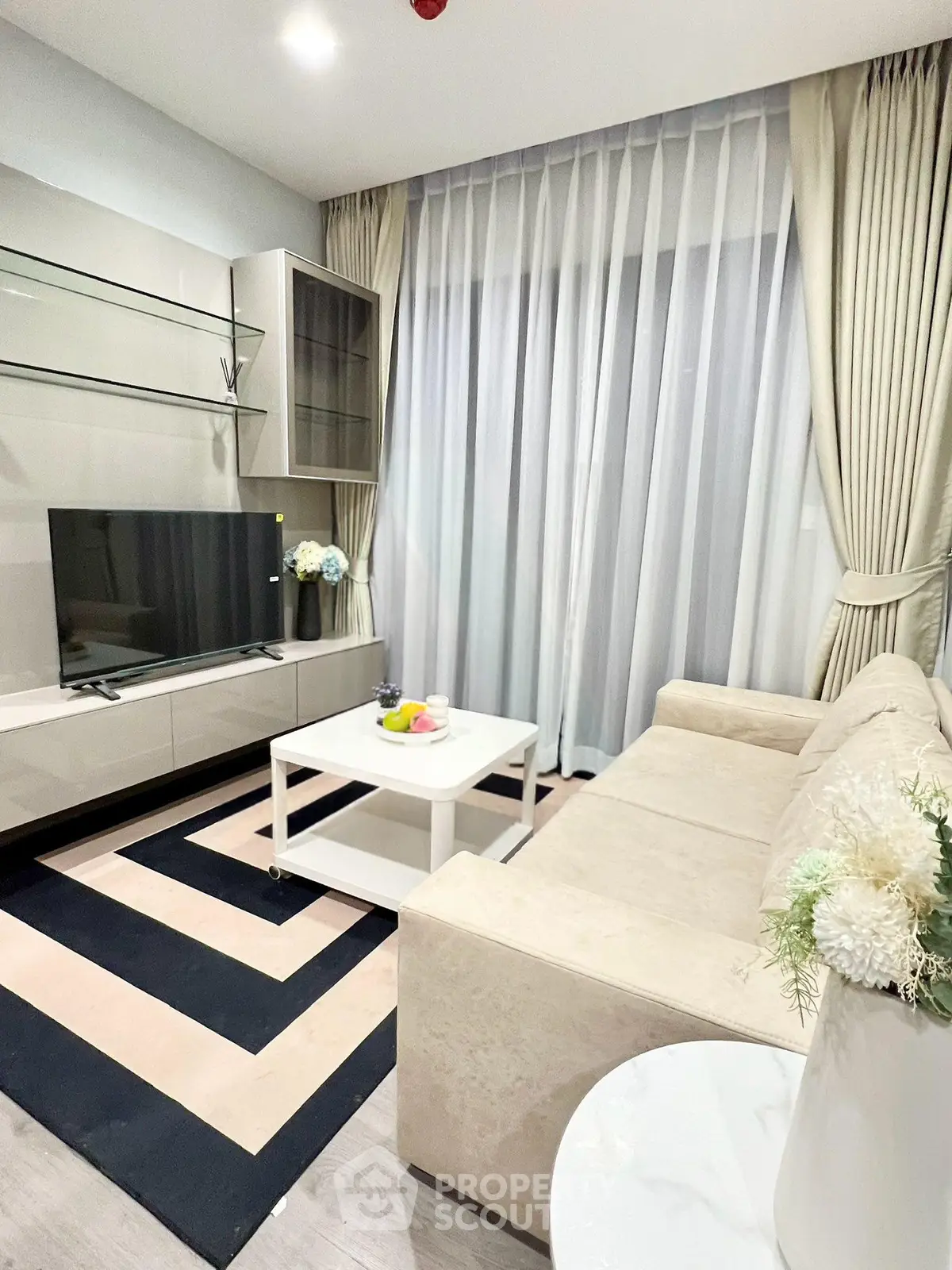 Modern living room with sleek furniture and large window drapes
