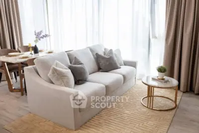 Elegant living room with plush sofa, stylish coffee table, and dining area, perfect for modern living.