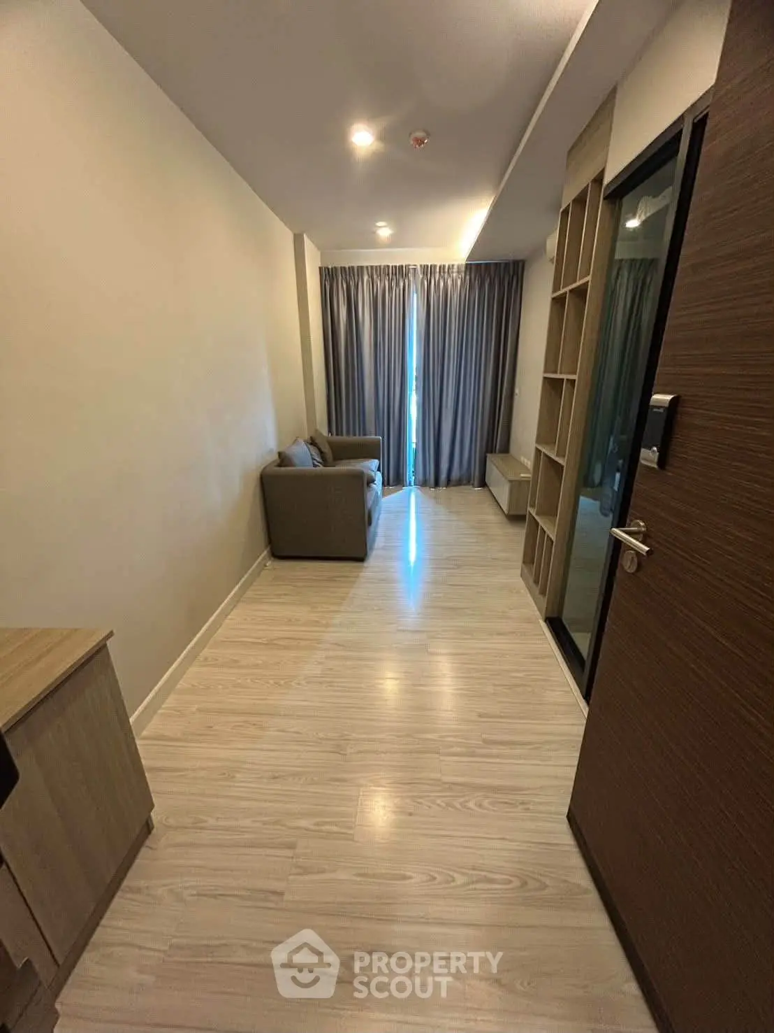 Modern living room with sleek design and cozy sofa, featuring elegant wooden flooring and ambient lighting.