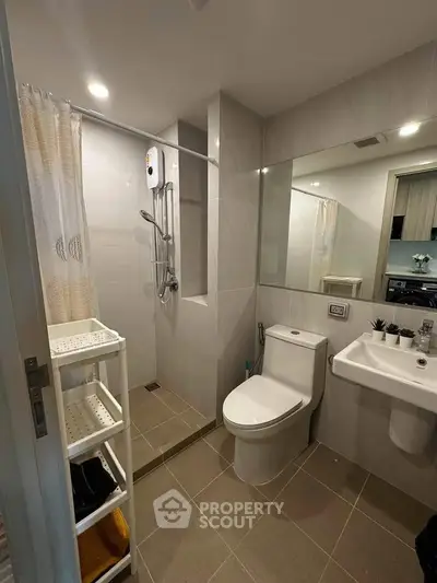 Modern bathroom with sleek fixtures and spacious shower area in a contemporary apartment.