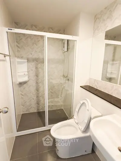 Modern bathroom with glass shower enclosure and sleek fixtures