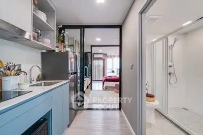 Modern apartment with sleek kitchen and cozy bedroom, featuring stylish decor and efficient layout.