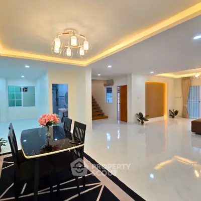 Spacious modern living and dining area with elegant lighting and open layout.