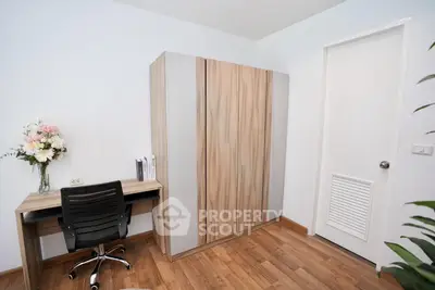 Modern study room with sleek desk, chair, and stylish wardrobe in a cozy apartment.