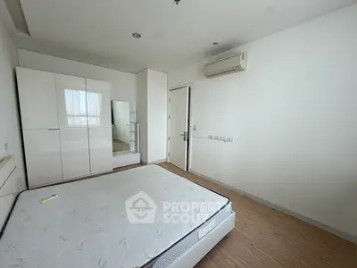 Spacious bedroom with modern white wardrobe and air conditioning unit, perfect for comfortable living.