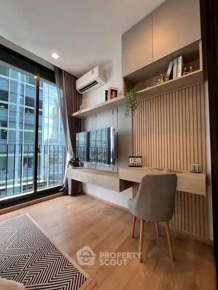 Modern living room with sleek design, large window, and built-in shelving in a high-rise apartment.