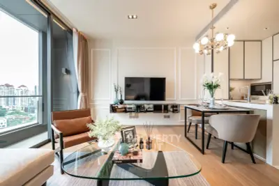 Luxurious modern living room with city view, elegant decor, and open kitchen layout in high-rise apartment.