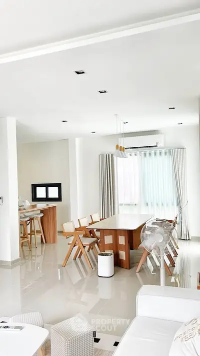 Spacious modern living room with elegant dining area and natural light