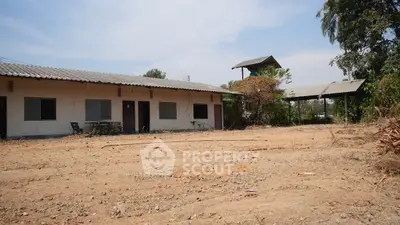 Spacious rural property with potential for development, featuring a single-story building and open land.