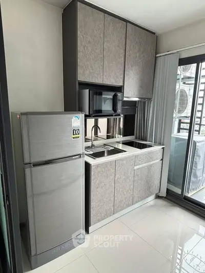 Modern kitchen with sleek cabinets and stainless steel appliances in a stylish apartment.