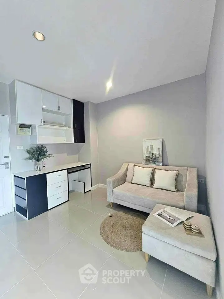 Modern living room with sleek furniture and neutral tones, featuring a cozy sofa and stylish decor.