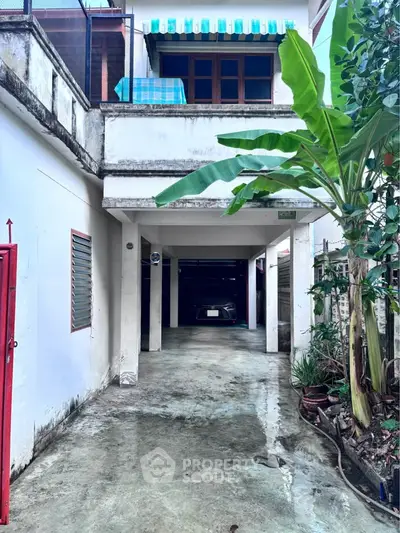 Charming residential property with covered parking and lush greenery, perfect for urban living.