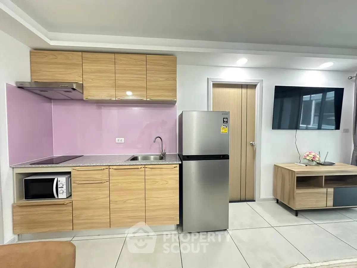 Modern kitchen with sleek cabinets and stainless steel appliances in a stylish apartment.