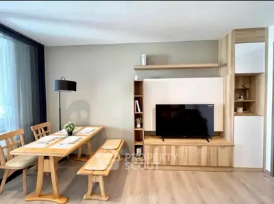 Modern living room with wooden furniture and dining area, featuring a sleek TV setup.