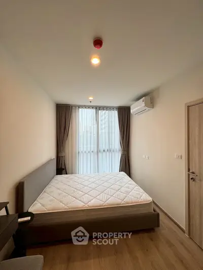 Modern bedroom with large window and air conditioning in a stylish apartment.