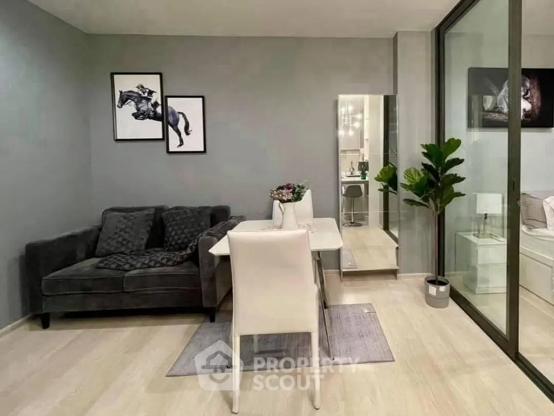 Modern living room with stylish decor and glass partition leading to bedroom
