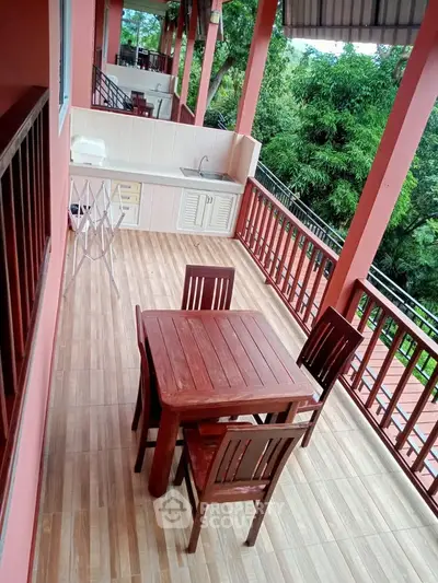 Spacious balcony with wooden furniture and outdoor sink, perfect for relaxation and entertaining.