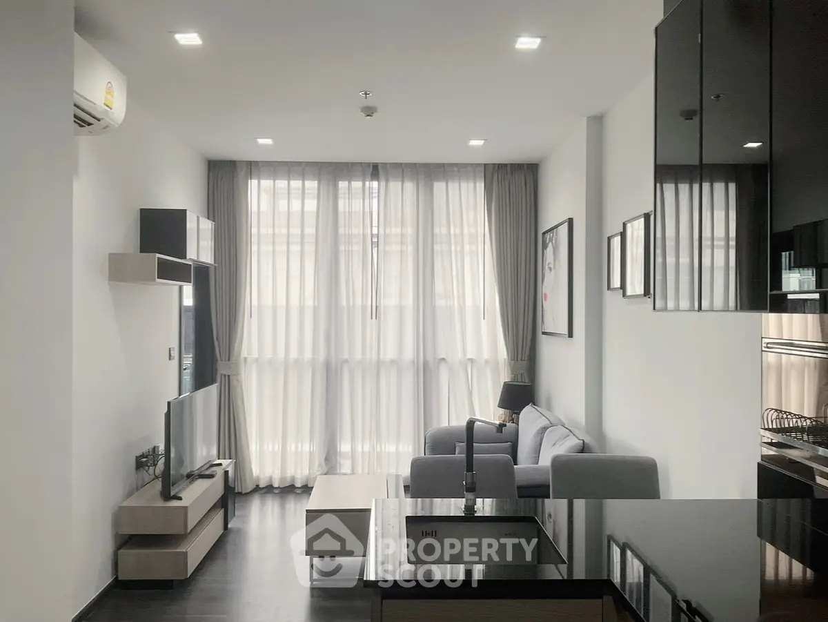 Modern living room with sleek design, large windows, and contemporary furniture in a stylish apartment.