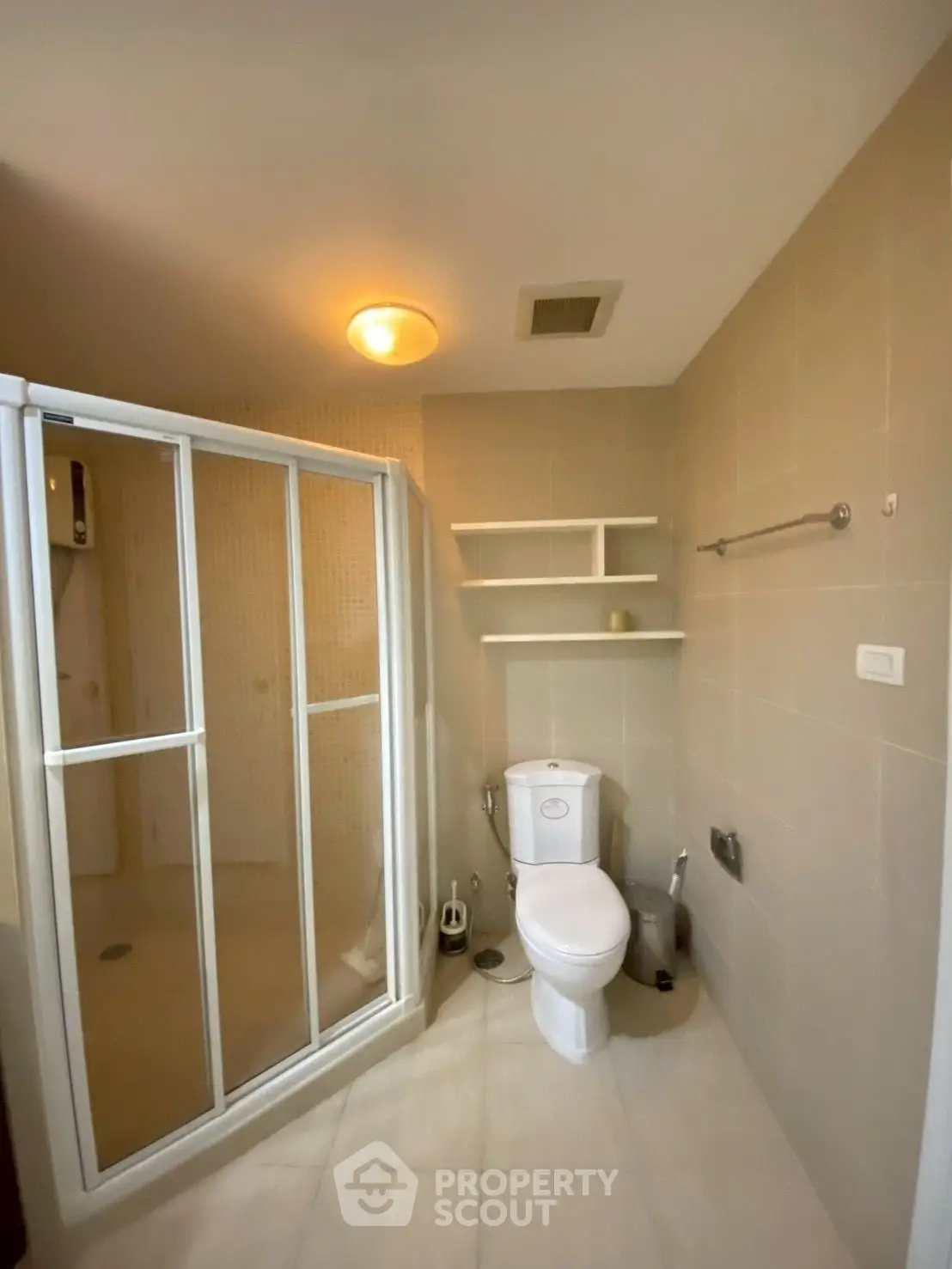 Modern bathroom with shower enclosure and toilet in a cozy apartment.