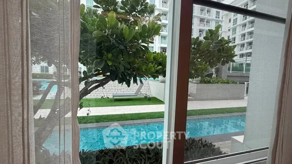 Luxurious apartment view with pool and lush greenery, offering serene and modern living experience.
