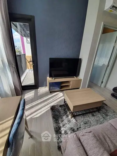 Modern living room with balcony access and stylish furniture in a cozy apartment.