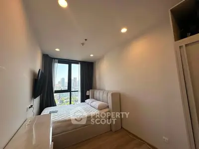 Modern bedroom with city view, featuring a cozy bed and sleek decor.