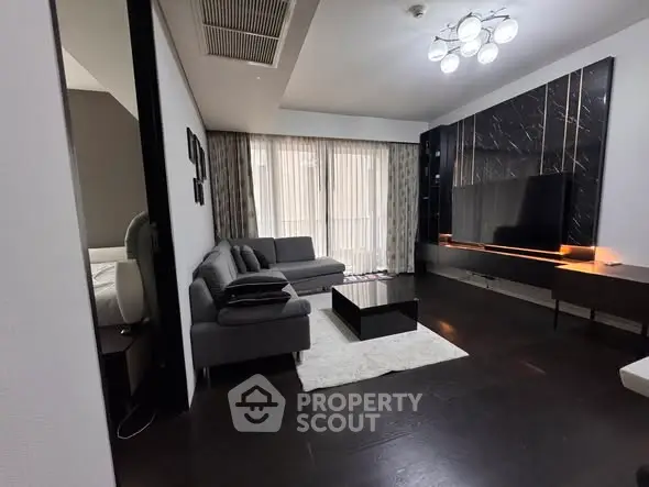 Modern living room with sleek black decor and large windows