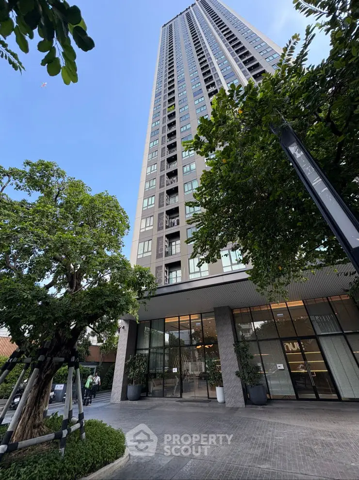 Stunning high-rise building with lush greenery and modern entrance