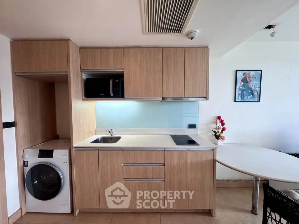 Modern compact kitchen with washing machine and sleek wooden cabinets