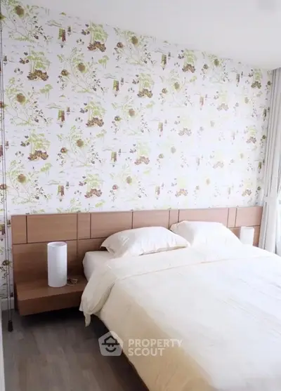 Charming bedroom with floral wallpaper and cozy bedding in modern apartment.